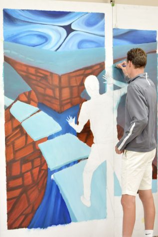 Alex Trunko paints a mural which will be displayed in the new wing of the first floor.