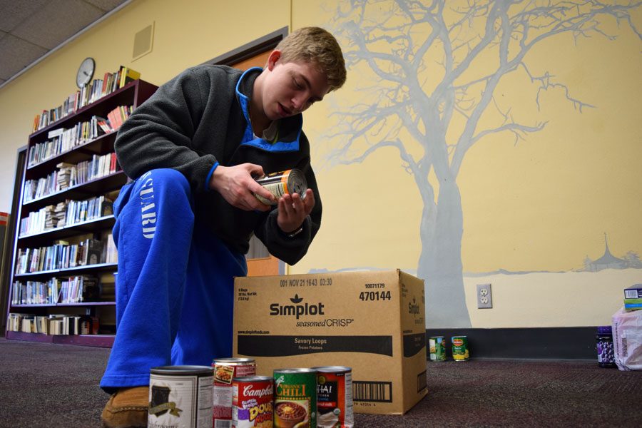 Student Body Secretary Sam Radetic organizes the canned goods for the mission week food drive.