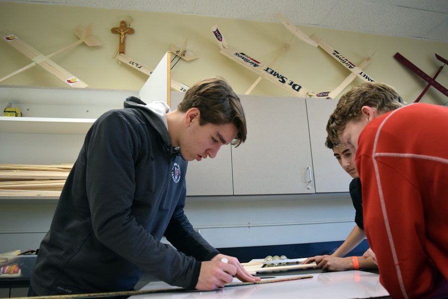 Seniors Christian Weishaar, Sal Alu and Tyler OConnor draw out plans for their glider, which is designed to carry rubber balls for the Boeing Engineering Competition.