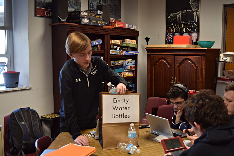 Sophomore Joel Roth puts bottles from room 210 into the Sustainability Committees bottle collection bag.