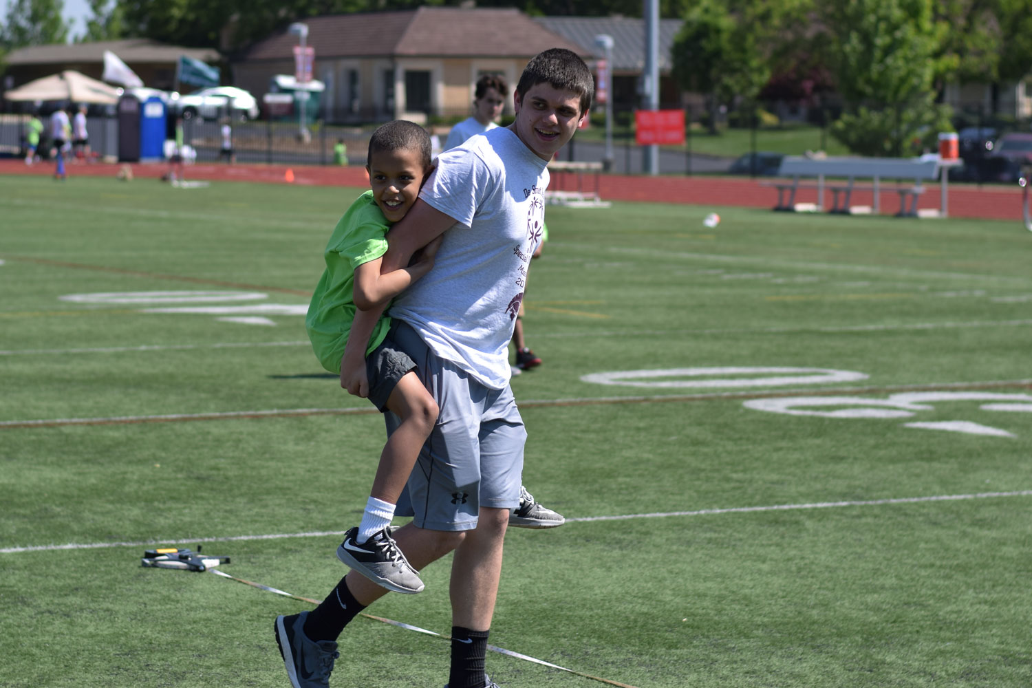 Joseph Pangelinan carries his buddy across the field during the Special Olympics