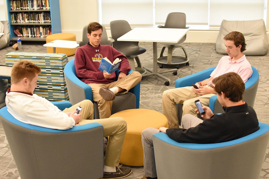 Students sit in the innovation center on social media while one reads the Gettysburg Address.
