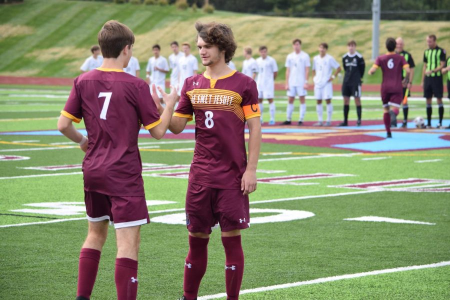 Senior captain Kyle Burke does handshake with senior Brayden Morgan prior to a game against SLUH.