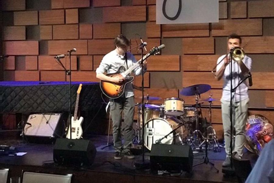 Aidan Bartholet tunes his guitar before a performance.