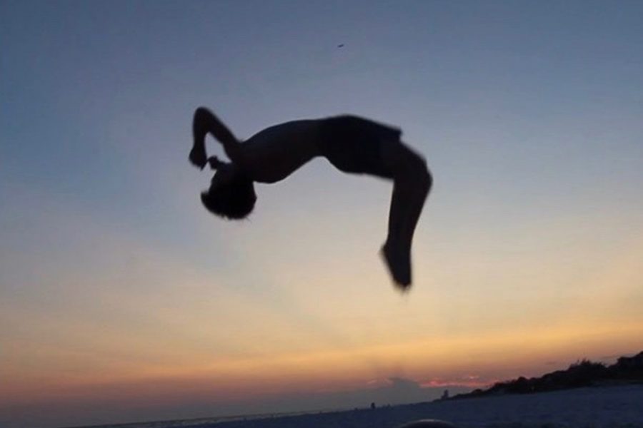 Freshman Slayton Spencer flips on the beach for his four thousand Instagram followers.