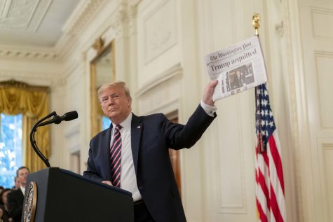 President Trump shows the Washington Post article written about him being acquitted.