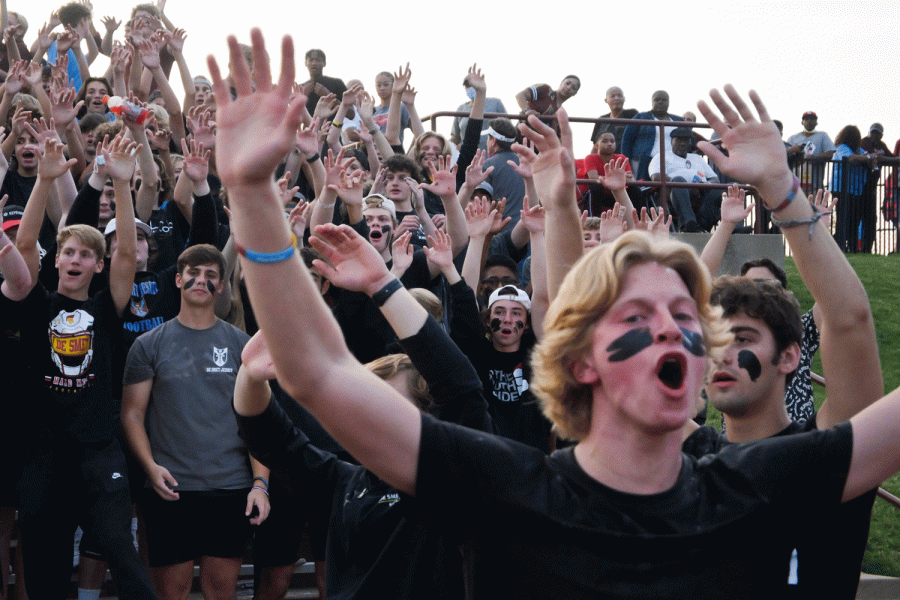 Colin+Brunts+leads+the+student+section+dressed+in+a+black+out+theme+ahead+of+the+opening+kickoff.+