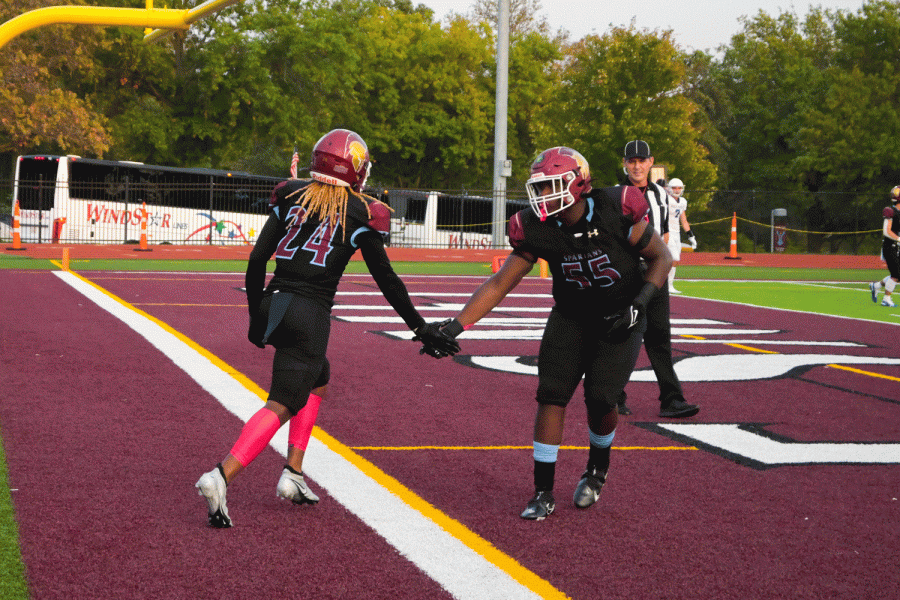 Running back Keshawn Ford runs into the end zone and scores a touchdown. Afterwards he celebrates with offensive lineman Bryson Rolle. 