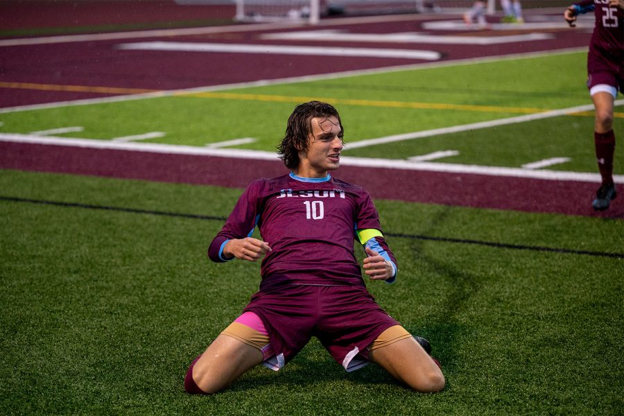 Anthony Grewe 22 slides across the turf to celebrate the opening goal versus Hickman. Coming into the game, Hickman had won their last 14 games. De Smet had a strong second half and capped it off with a 5-2 win to move to 8-6 on the season.