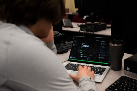 Colby Quinn 24 listens to popular music artist Drake with his school-issued laptop.