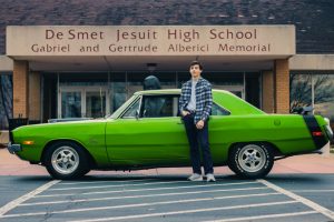 David Breuer 23 poses in front of his 1972 Dodge Dart that he races in competitions.