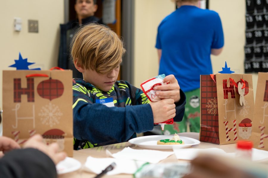 A Christmas On Campus participant decorates cookies at the cookie making station.
