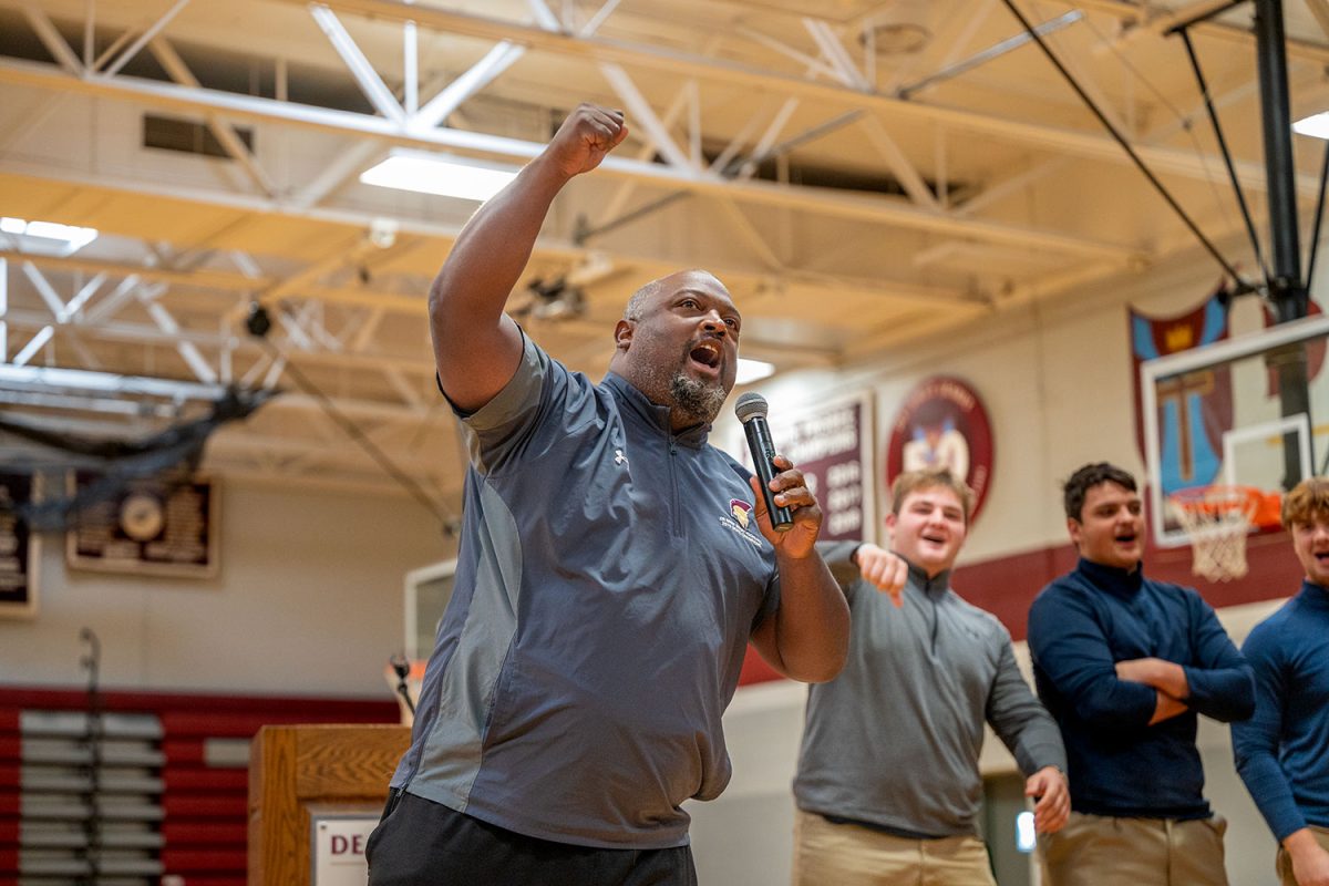 Head football coach John Merritt leads the students in a chant of STUFF THE BUS during the Great Ignatian Challenge kickoff assembly Oct. 18.