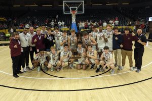 The Spartans basketball team celebrates with the Class 5 Basketball State Championship trophy after beating Jeff City 75-56 March 14 at Mizzou Arena. 
