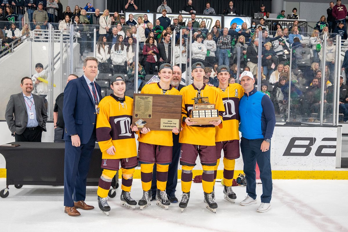De Smet captains Theo Porter 24, Jack Croghan 24, Grant Fowlkes 24, and Collin Osdieck 24 accept the Challenge Cup championship trophies after beating Marquette 3-0 March 2 and Centene Ice Center.