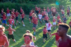 Students run on to the field during the running of the Spartans last year before the opening Friday night football game against Chaminade. The event will take place at the home opening soccer game this year.