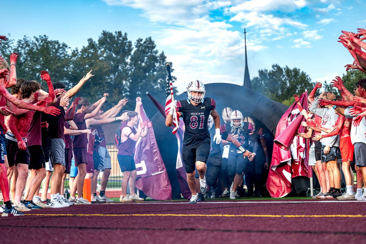 The football team runs out of the tunnel against Chaminade last season. They are preparing to face fellow Jesuit school Creighton Prep on Saturday.