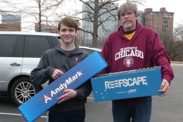 DuRT team member Tommy Zeigler '25 and coach Rob Behm accept the official materials Jan 4 to kick off the 2025 First Robotics Competition (FRC) season.