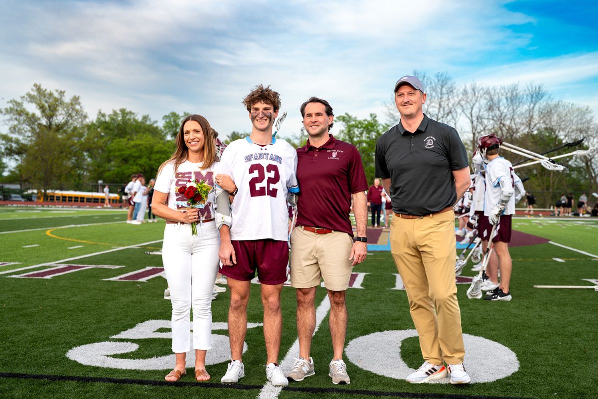 Jack Killion '25 stands with parents and coach for senior celebration on April 23rd, 2025.