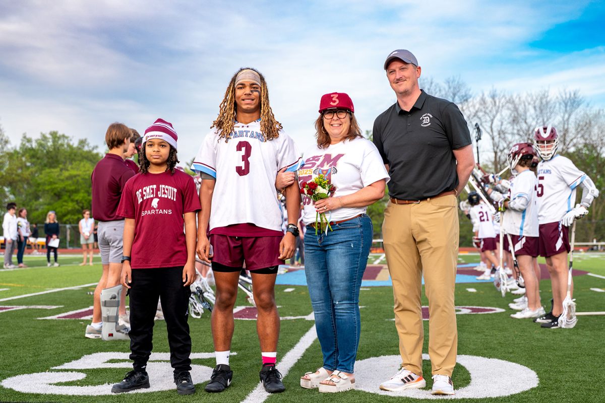 Alex Gibbs '25 stands with family and coach for senior celebration on April 23rd, 2025.