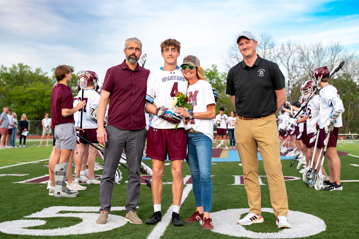 Evan Mortimer '25 stands with parents and coach for senior celebration on April 23rd, 2025.