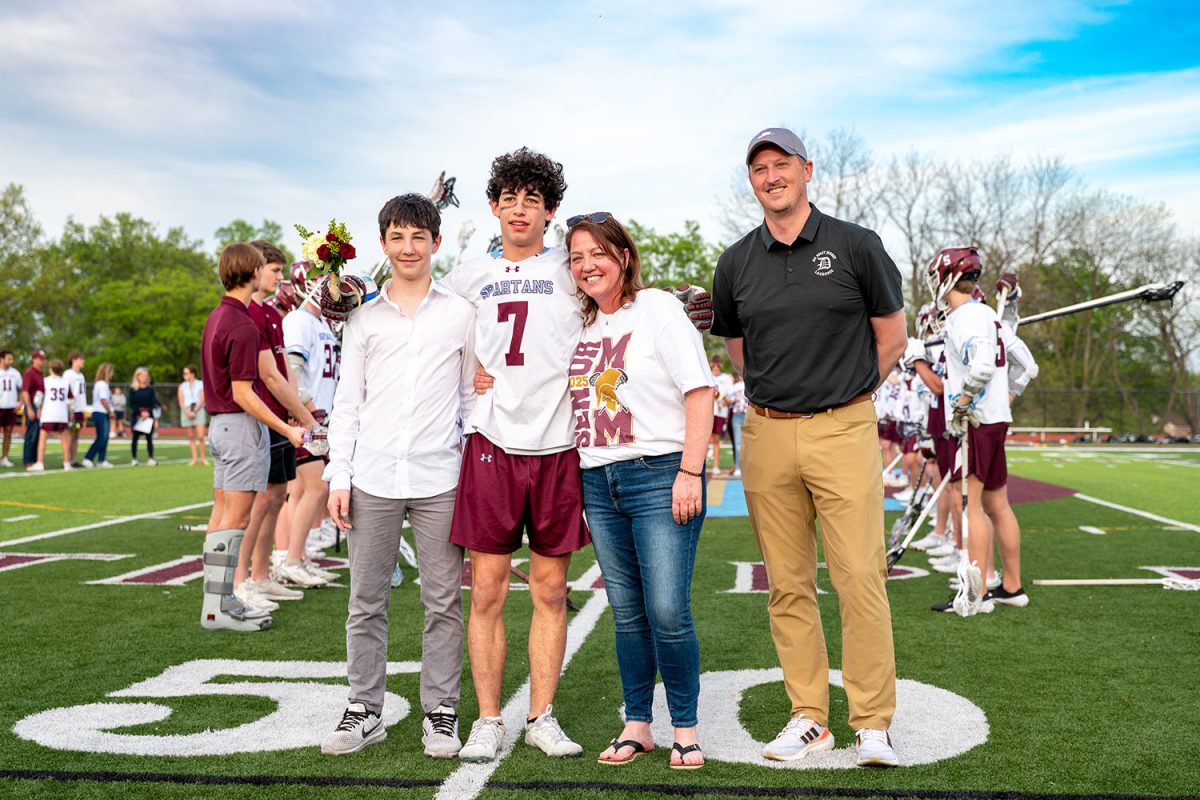 Maxwell Diamond '25 stands with family and coach for senior celebration on April 23rd, 2025.