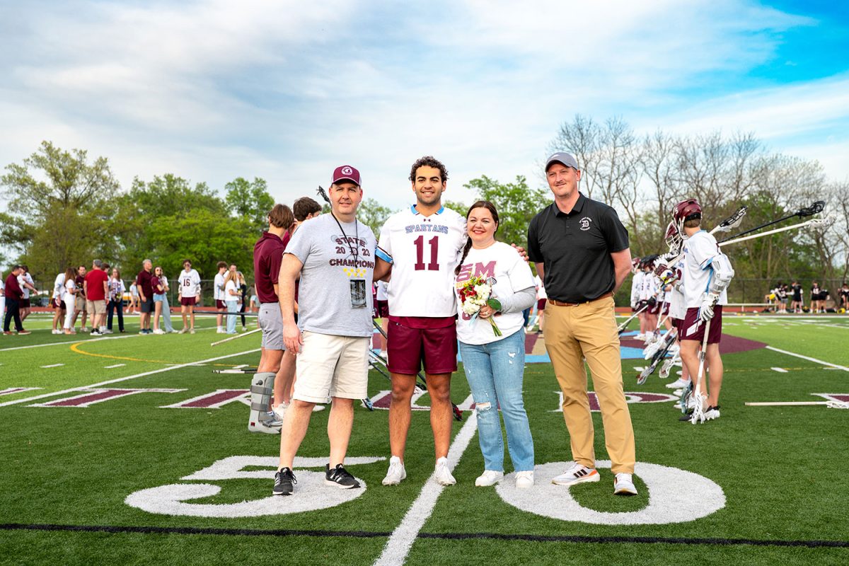Henry Barreca '25 stands with parents and coach for senior celebration on April 23rd, 2025.