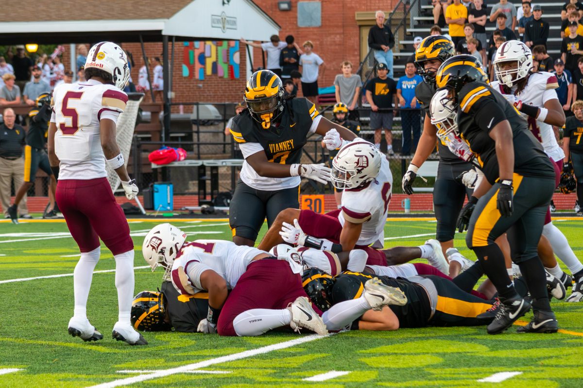 Spartan defenders combine for a tackle to stall the Vianney offense.