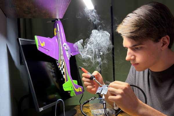 Alex Miller 26' tinkers with a motherboard to prepare his model plane for flight. Photo curtesy of Alex Miller 26'