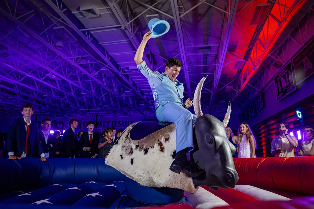 Jake Strahlendorf 26' rides the mechanical bull like a cowboy at the Spartanfest Homecoming dance on Oct. 4, 2025.