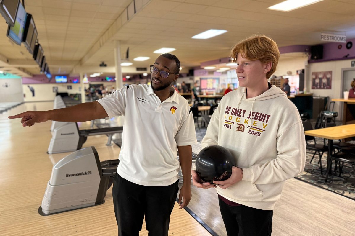 Head Bowling Coach Justin Thomas '21 coaching Ethan Deelo '26 at Olivette Lanes during a match.