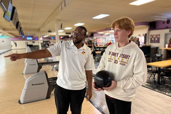 Head Bowling Coach Justin Thomas '21 coaching Ethan Deelo '26 at Olivette Lanes during a match.