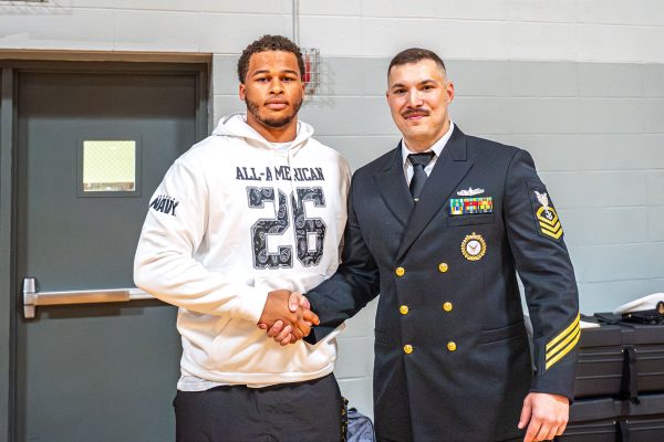 Navy  Chief Petty Officer Dustin Supachana presents senior defensive lineman Titan Davis with an invitation to the 2026 Navy All-American game. The game will be played at the Alamodome in San Antonio on Jan. 10.