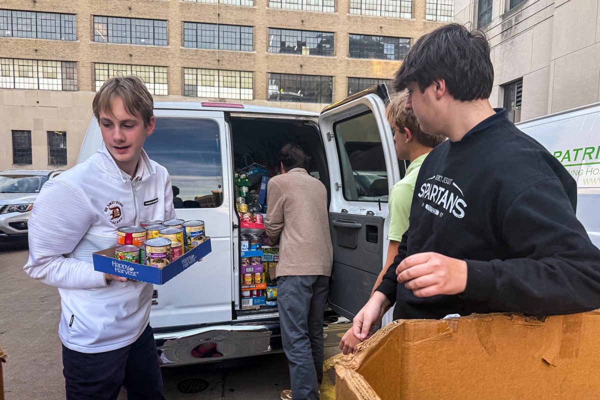Luke Dagenais '27, Jose Mares '26, Landon Oppeau '26, and Jimmy Appel '26 unload a bus filled with cans at the St. Patrick Center on Nov. 4th.