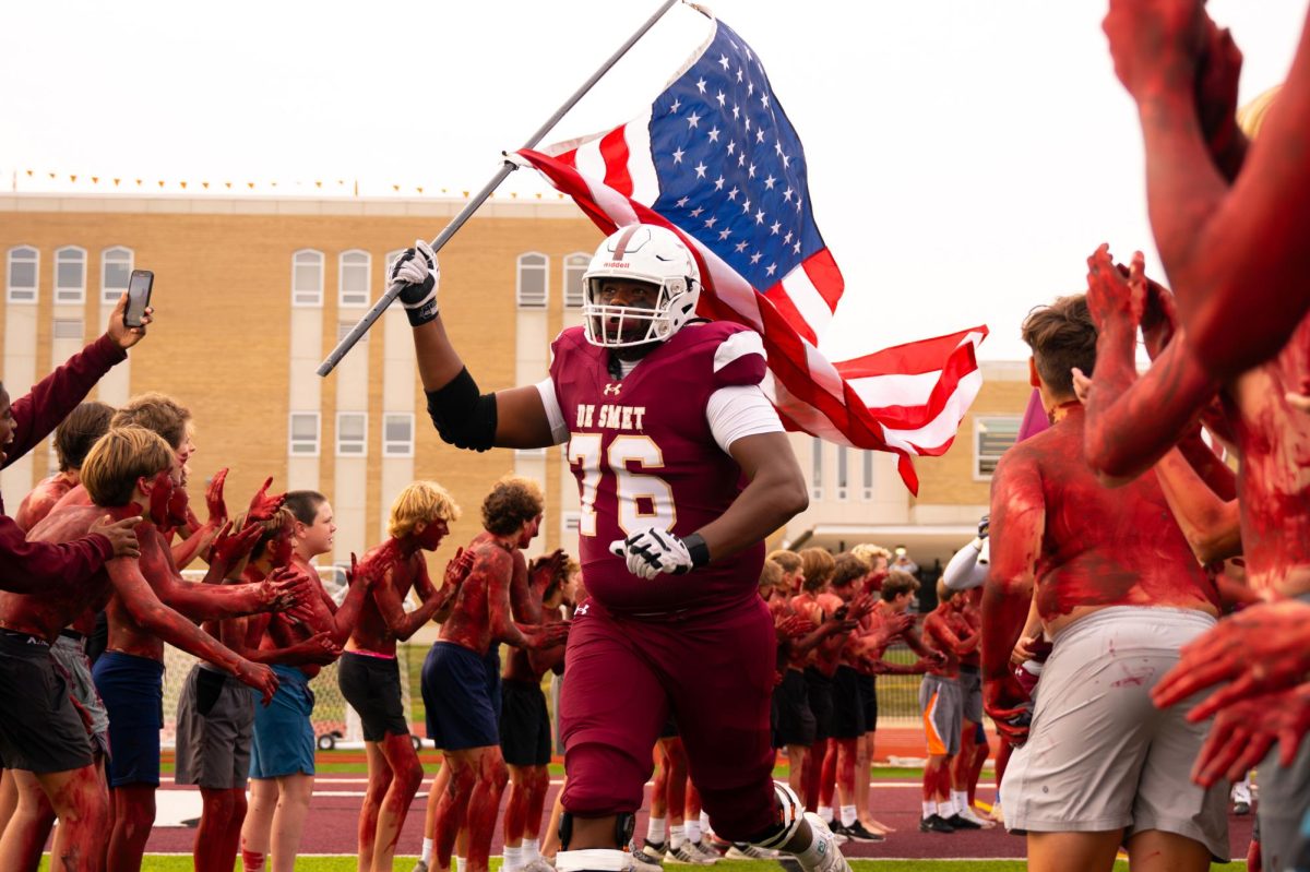 Santiago Castillo 26' leads his team out to the field while demonstrating his patriotism in first home game of the season against MICDS on Sept. 5.
