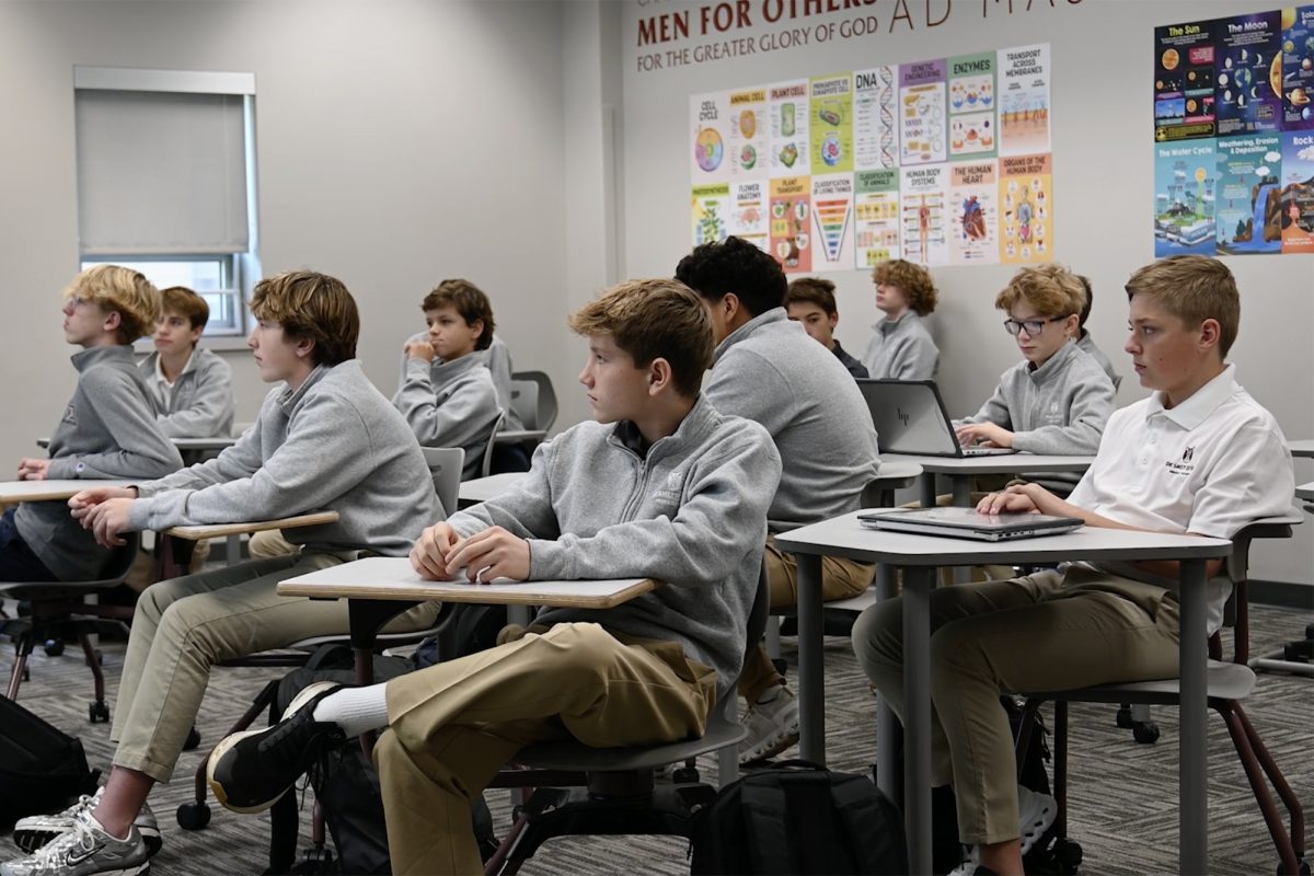 Middle School students in a classroom listening to a teachers lesson.