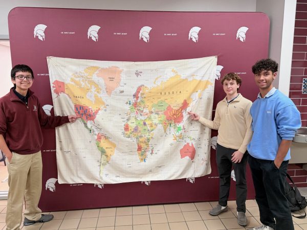 Students who took part in the week 3 map initiative pointing to the parts of the world where their clothes were manufactured to bring awareness. 