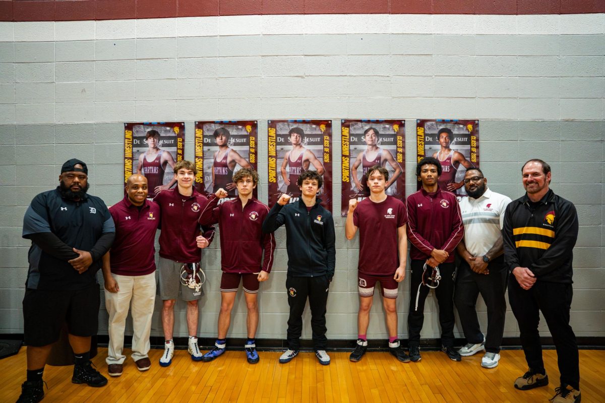 Seniors stand with their coaches under their banners to celebrate senior night on Jan. 14, 2026.