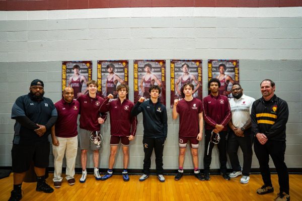 Seniors stand with their coaches under their banners to celebrate senior night on Jan. 14, 2026.