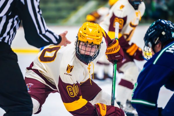 Owen Mcenaney '29 stares down the puck, readying for a face-off in the game vs Marquette on Nov. 25 2025