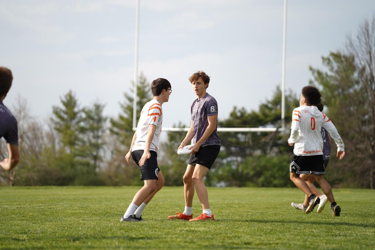 Junior Luke Mabry holds the disc in the air and looks for a player to throw it to down the field.